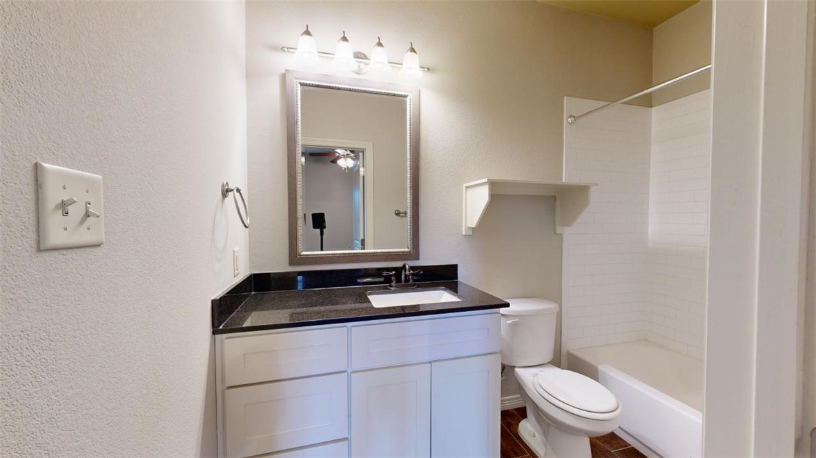 102 Richards Street College Station, TX 77840 - Photo 18 of 41 a bathroom with a granite countertop sink toilet and mirror