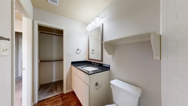 a bathroom with a granite countertop toilet and sink