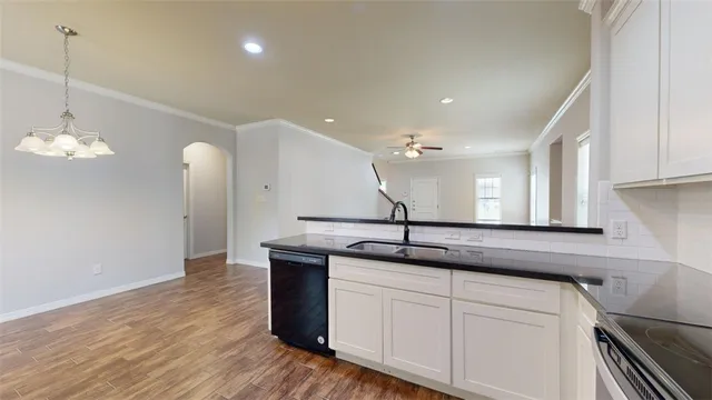 a kitchen with granite countertop a refrigerator and a sink