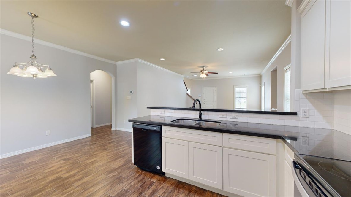 102 Richards Street College Station, TX 77840 - Photo 7 of 41 a kitchen with a sink chandelier and wooden floor