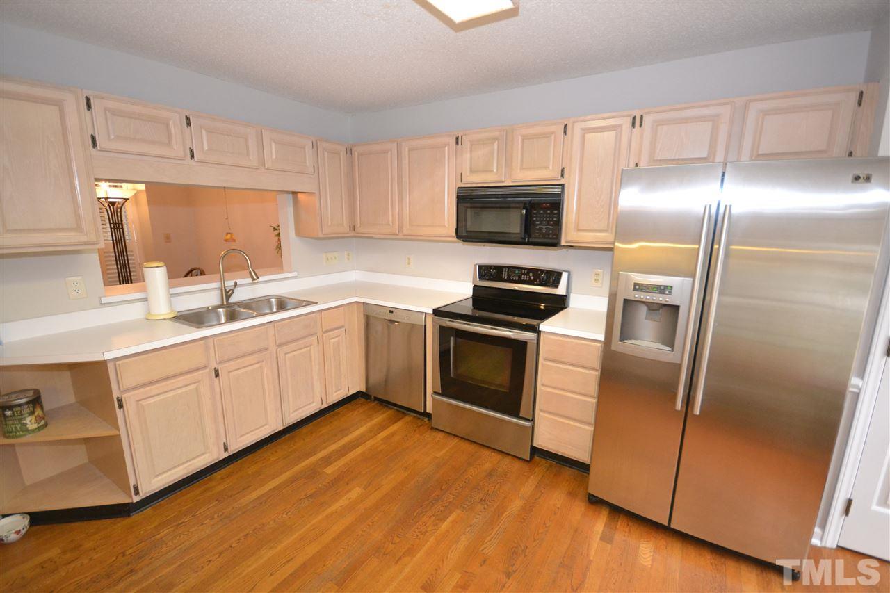 24 Renwick Court Raleigh, NC 27615 - Photo 4 of 20 a kitchen with white cabinets stainless steel appliances and a sink