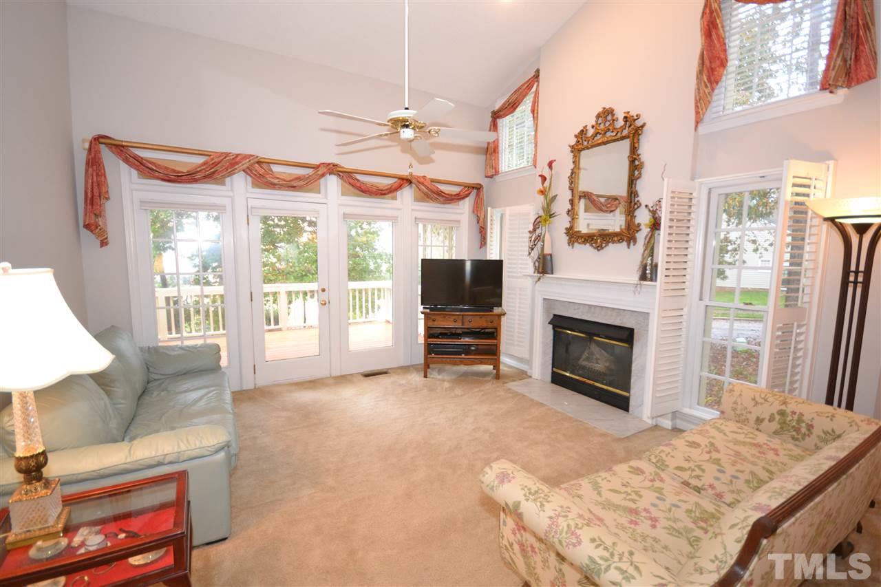 24 Renwick Court Raleigh, NC 27615 - Photo 7 of 20 a living room with furniture a fireplace and a flat screen tv