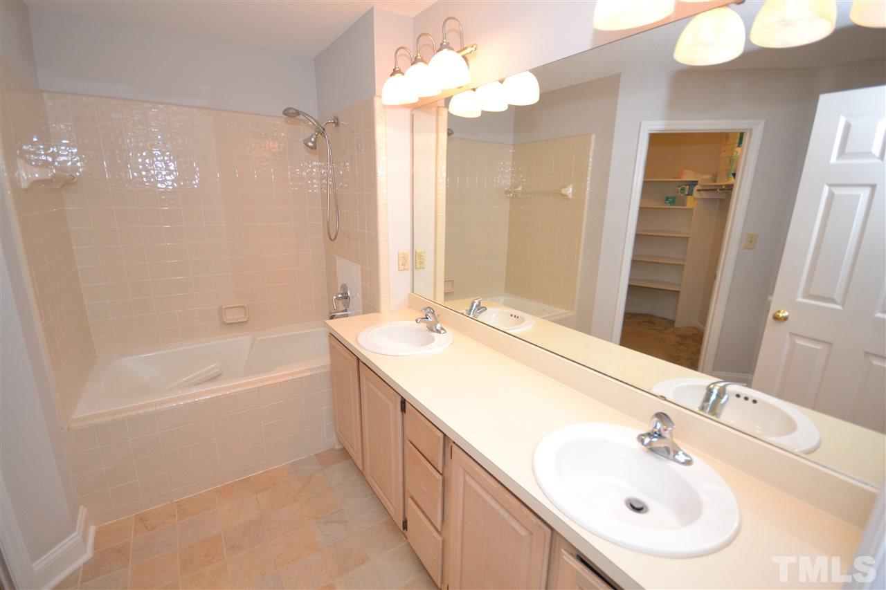 24 Renwick Court Raleigh, NC 27615 - Photo 9 of 20 a bathroom with a sink a tub and a mirror
