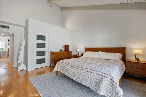 a bedroom with a bed and wooden floor