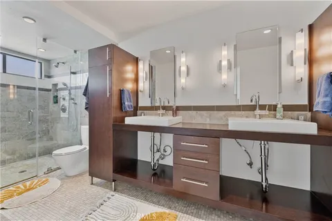 a bathroom with a sink a toilet and shower