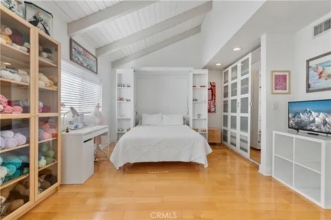 a spacious bedroom with a bed and a cabinets