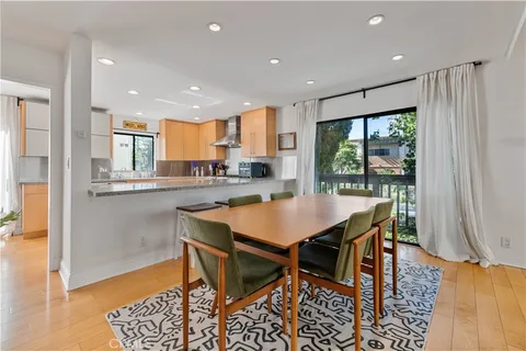 a kitchen with stainless steel appliances granite countertop a table chairs and a refrigerator