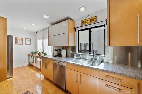 a large kitchen with a lot of counter space and wooden floor