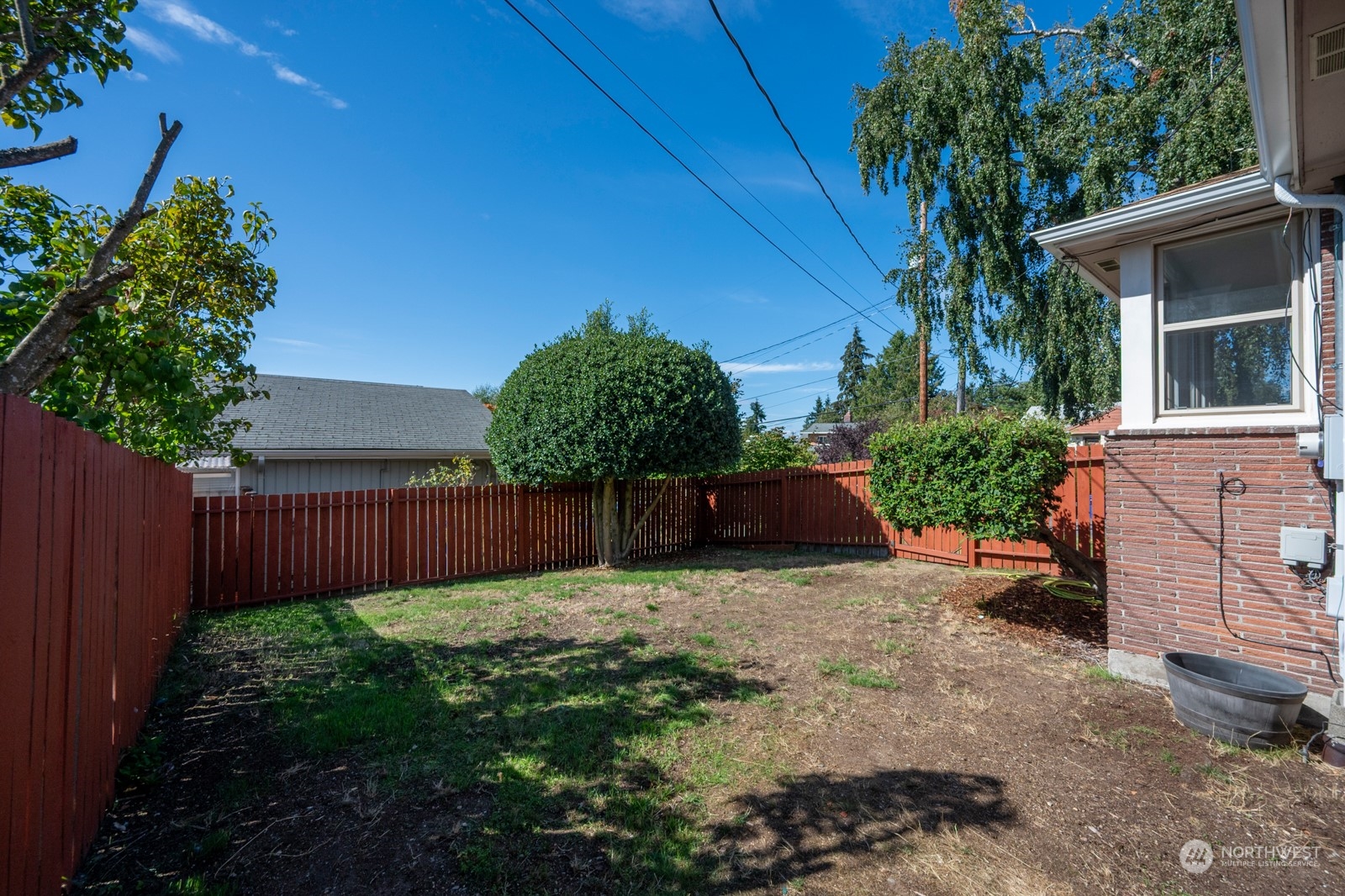 4105 Southwest Monroe Street Seattle, WA 98136 - Photo 29 of 31 a view of a backyard with potted plants and a wooden fence