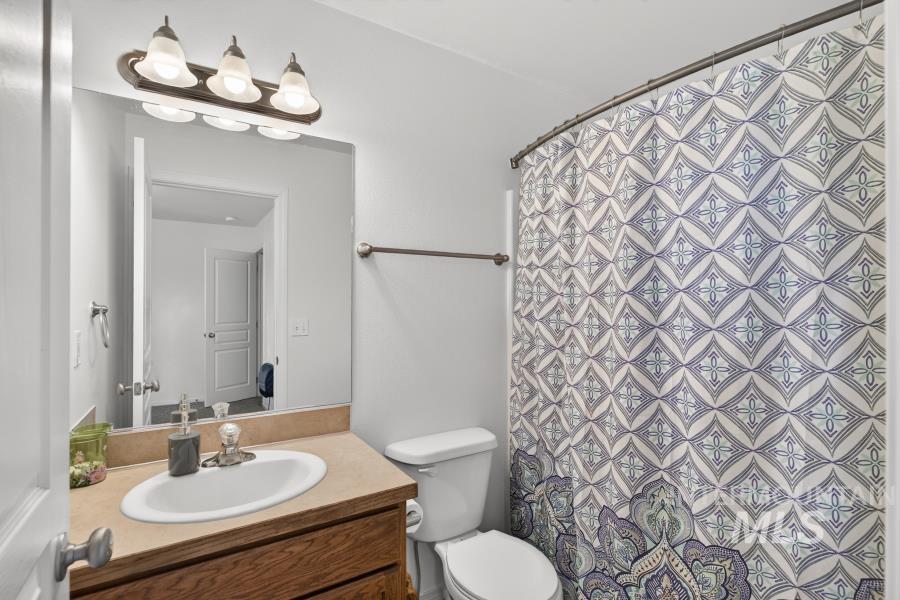 1337 Bristol Road Moscow, ID 83843 - Photo 21 of 28 Full bathroom featuring a single vanity with wood-finish cabinetry, a rectangular mirror, and a three-light fixture