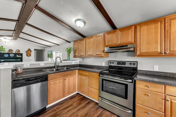 a kitchen with stainless steel appliances a stove sink microwave and cabinets