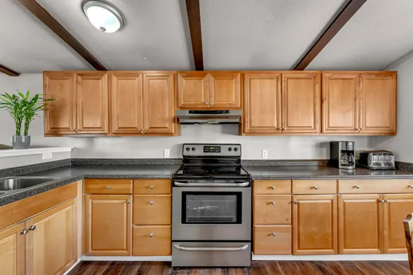 a kitchen with granite countertop white cabinets and white appliances