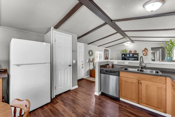 a kitchen with granite countertop a refrigerator and a sink