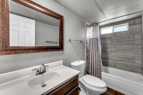 a bathroom with a sink toilet a mirror and shower