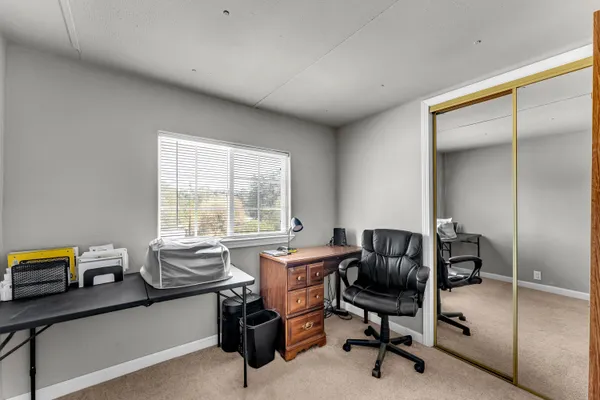 a view of a workspace with furniture and a window