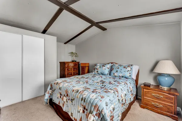 a bedroom with a bed and a lamp on the dresser