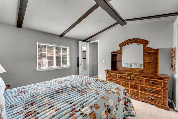 a bedroom with a bed and a dresser with the floor