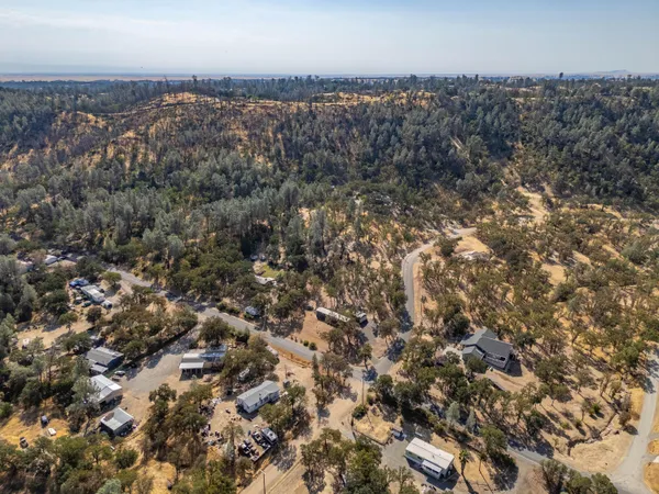 an aerial view of house with yard and mountain view in back