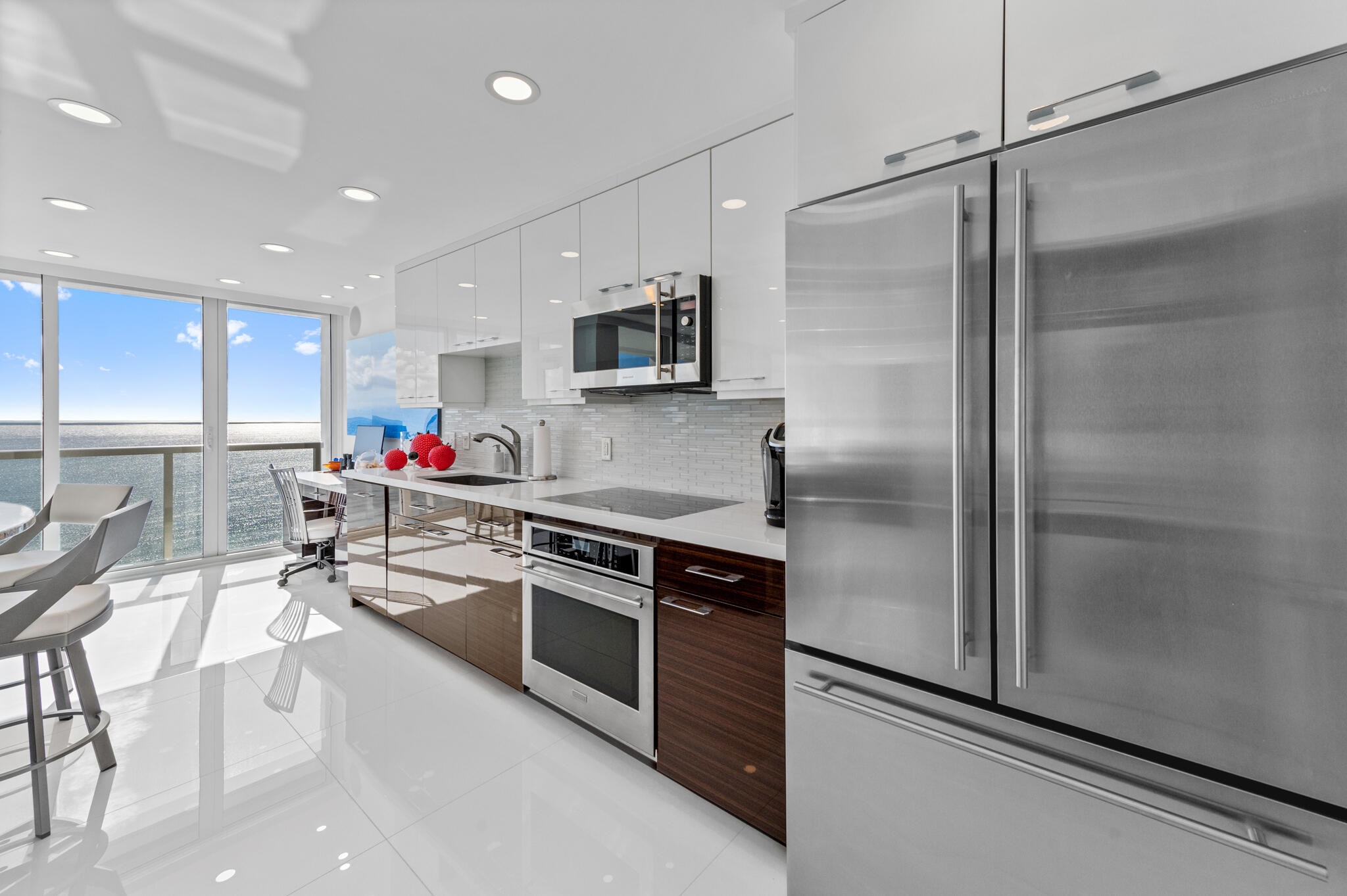 2800 South Ocean Boulevard, Unit 21E Boca Raton, FL 33432 - Photo 12 of 60 a kitchen with kitchen island white cabinets and stainless steel appliances