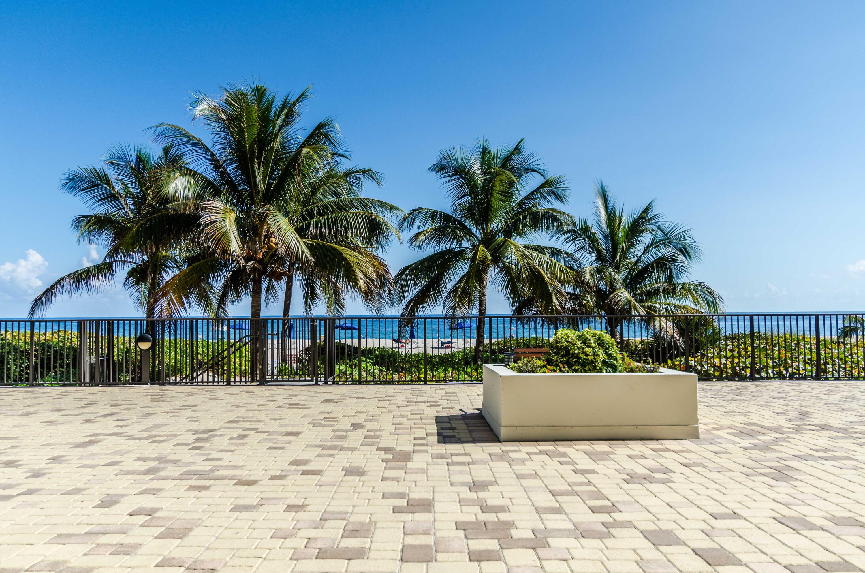 2800 South Ocean Boulevard, Unit 21E Boca Raton, FL 33432 - Photo 53 of 60 a view of a white house with a yard and potted plants