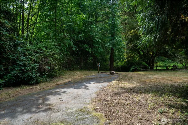 a kitchen with stainless steel appliances kitchen island granite countertop a table chairs sink and cabinets