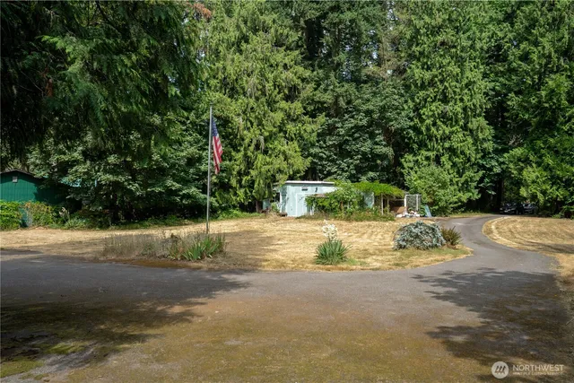 a backyard of a house with table and chairs and potted plants