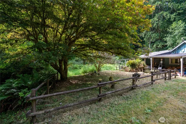 an aerial view of residential house with outdoor space and trees all around