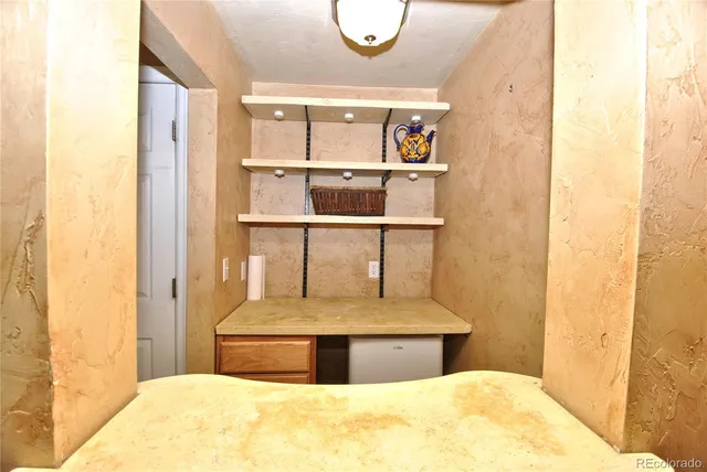 a view of room with furniture and wooden shelves