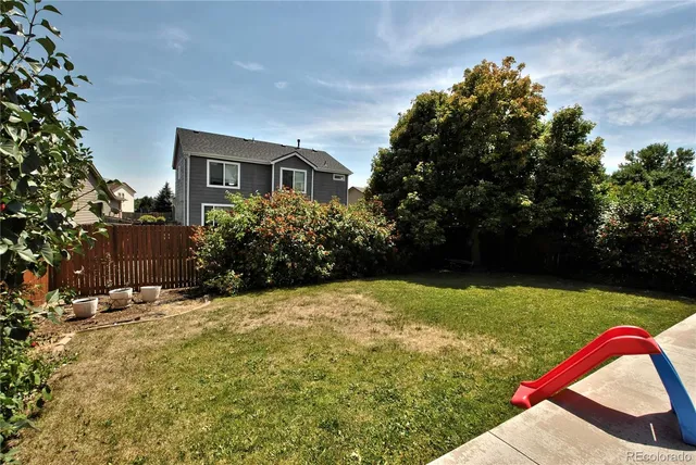 a roof deck with a table and chairs with wooden floor