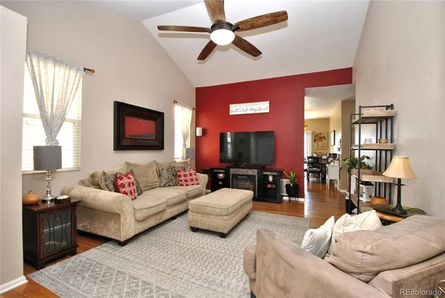 a living room with furniture flat screen tv and a large window