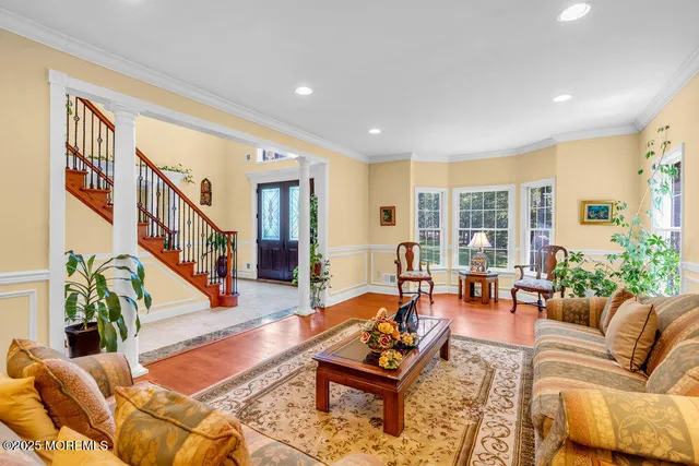 a living room with furniture kitchen view and a large window