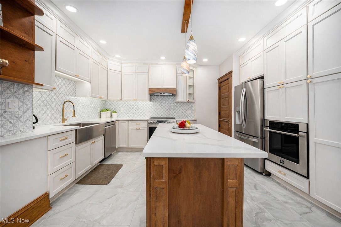 33895 Lorain Road North Ridgeville, OH 44039 - Photo 2 of 24 Kitchen with a center island, light stone counters, open shelves, and appliances with stainless steel finishes