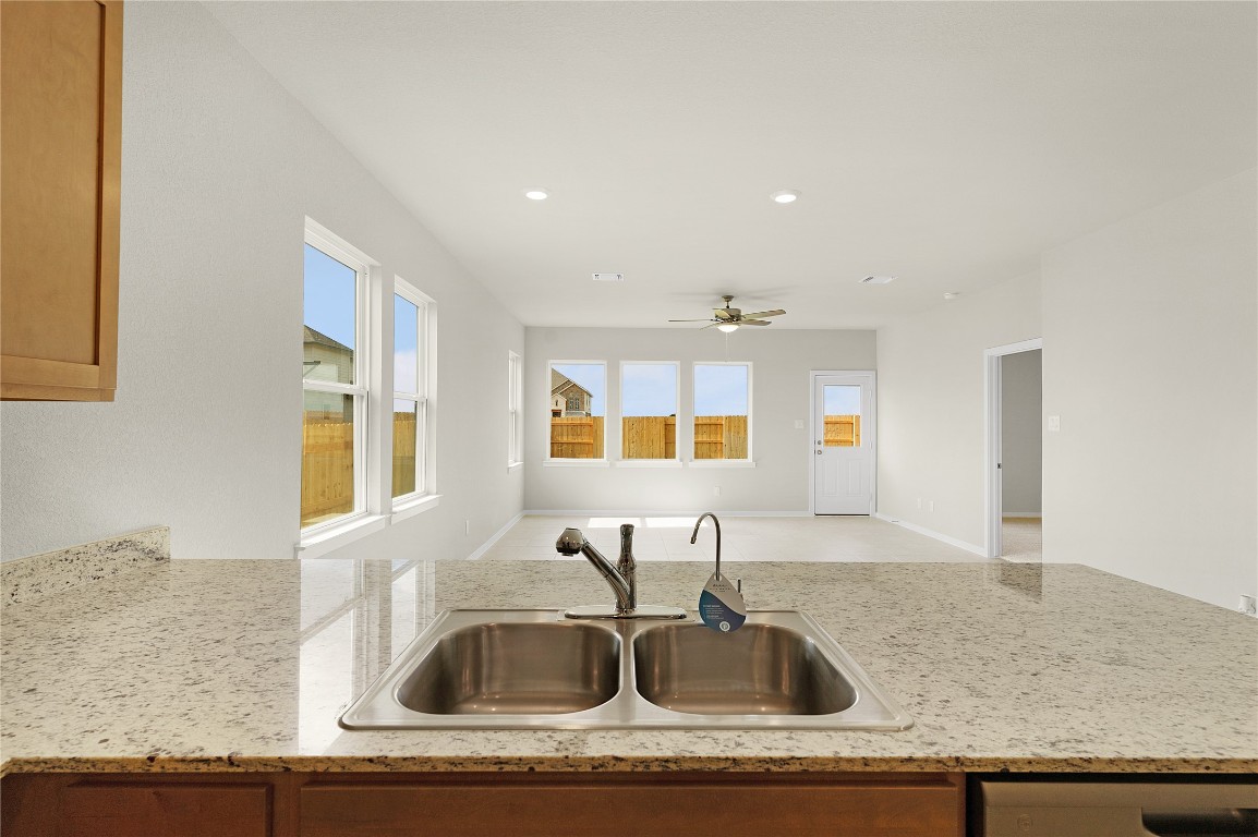 25624 Wheat Seed Lane Elgin, TX 78621 - Photo 18 of 40 a kitchen with granite countertop a sink and a wooden floor
