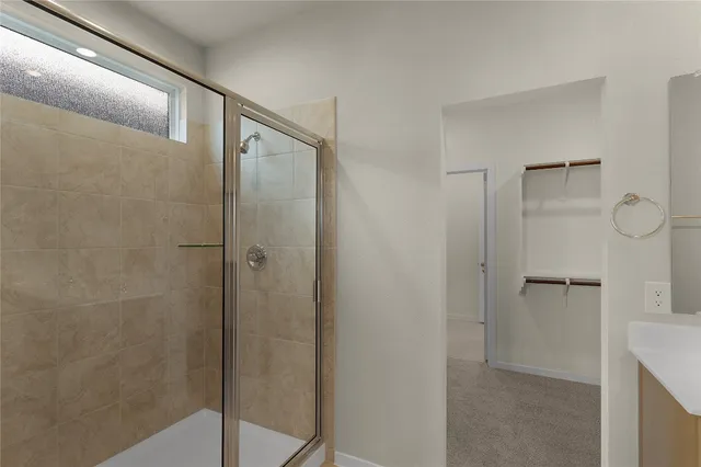 a view of an empty room with closet and a bathroom