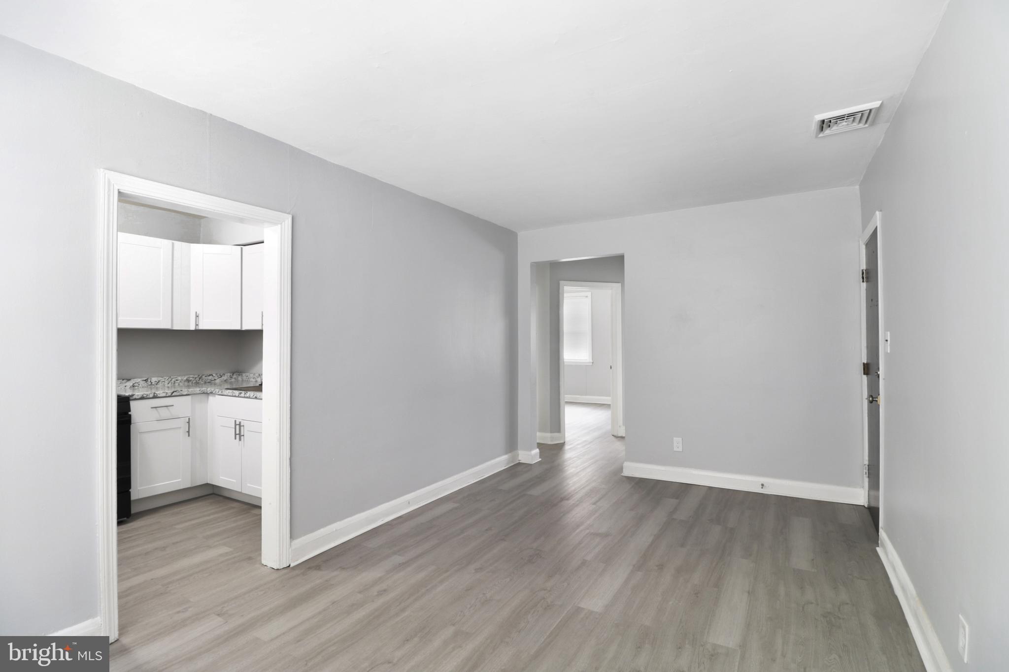 6151 Chinquapin Parkway Baltimore, MD 21239 - Photo 12 of 22 a view of an empty room and window and wooden floor