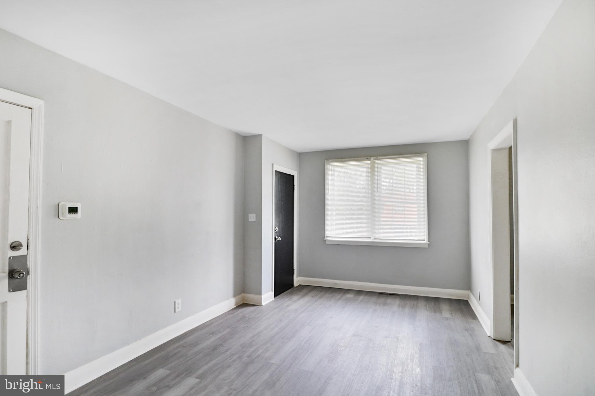 6151 Chinquapin Parkway Baltimore, MD 21239 - Photo 3 of 22 an empty room with wooden floor and windows