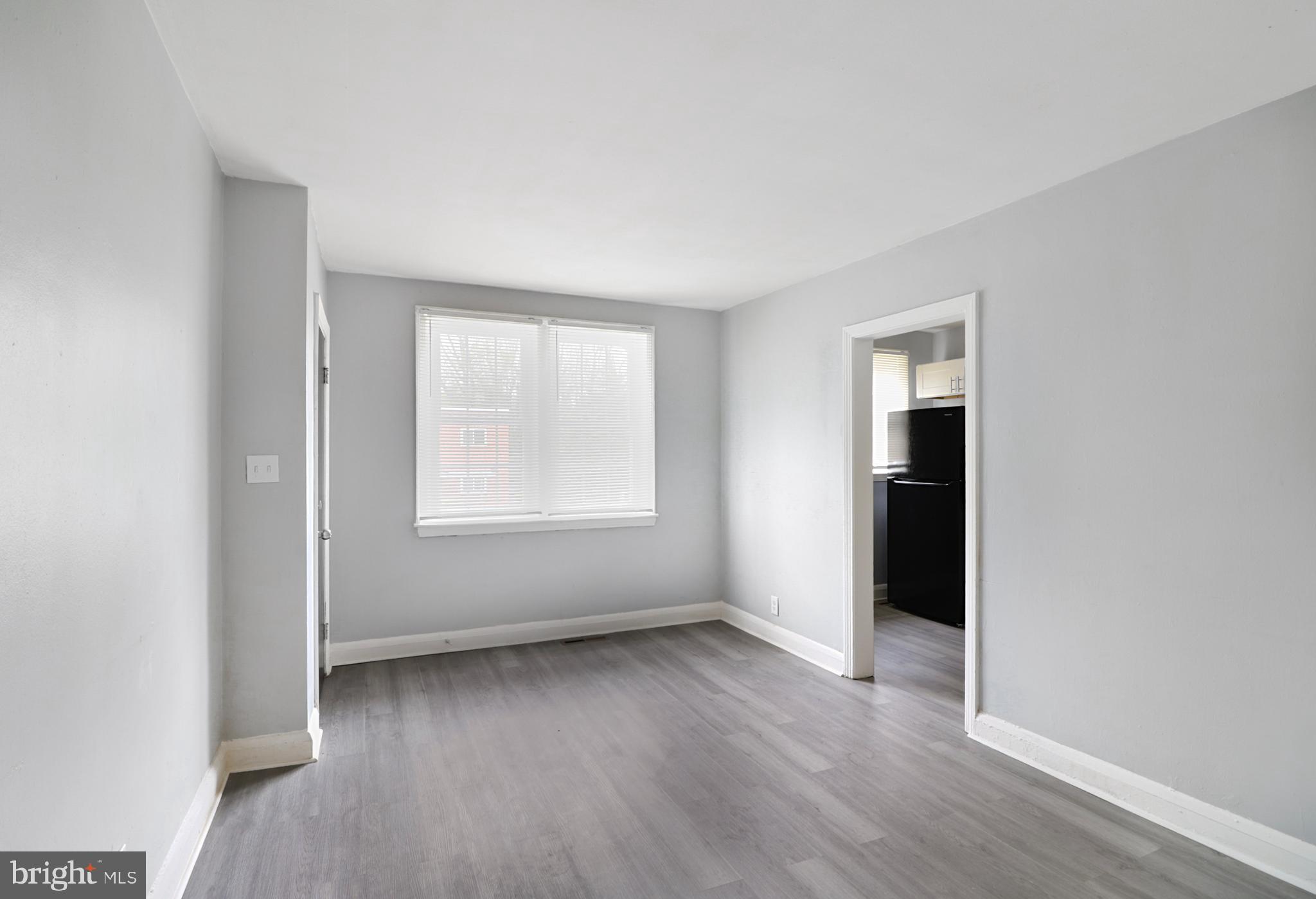 6151 Chinquapin Parkway Baltimore, MD 21239 - Photo 4 of 22 an empty room with wooden floor and windows