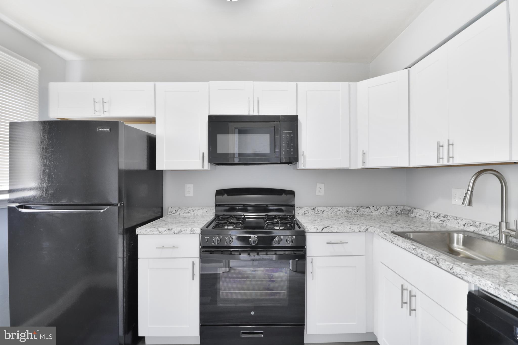 6151 Chinquapin Parkway Baltimore, MD 21239 - Photo 6 of 22 a kitchen with appliances a sink and cabinets