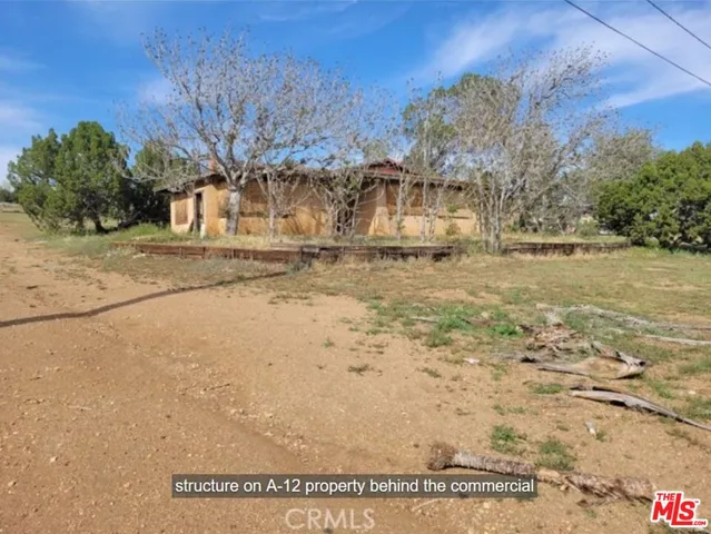 a view of a yard with wooden fence