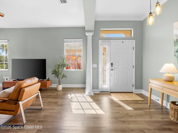 a living room with furniture kitchen view and a chandelier