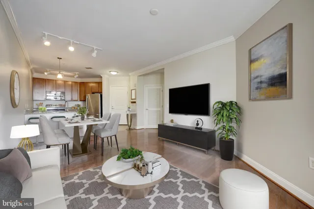 a living room with furniture a flat screen tv and a dining table