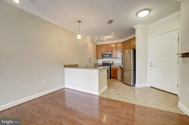 a kitchen with a refrigerator and white cabinets