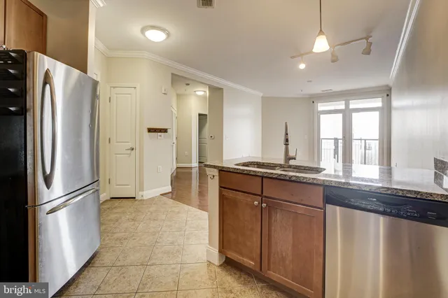 a kitchen with stainless steel appliances granite countertop a refrigerator and a sink