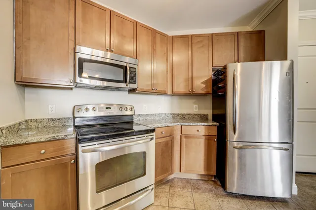 a kitchen with stainless steel appliances granite countertop a refrigerator stove a sink and microwave