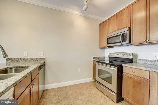 a kitchen with granite countertop cabinets stainless steel appliances and a sink