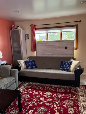 a living room with furniture a rug and a table