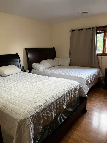 a bedroom with a bed lamp and a large window