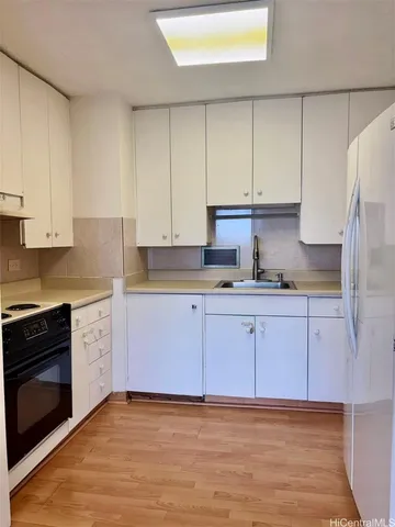 a kitchen with granite countertop a stove a sink and a refrigerator