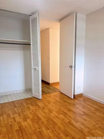 an empty room with wooden floor and closet