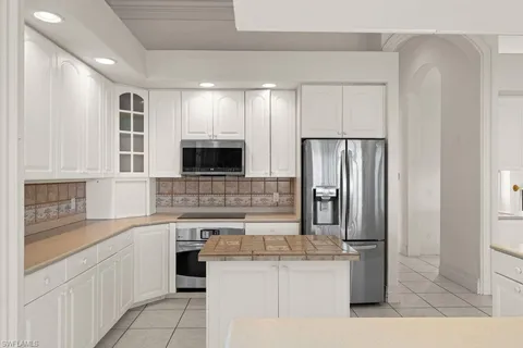 a kitchen with stainless steel appliances granite countertop a refrigerator and a stove top oven